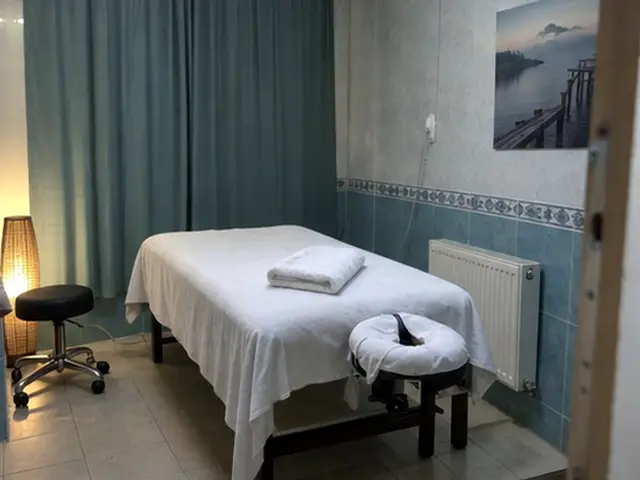 Mavi perdeli odada masaj masası ve tabure — Maslak, Masaj Salonun